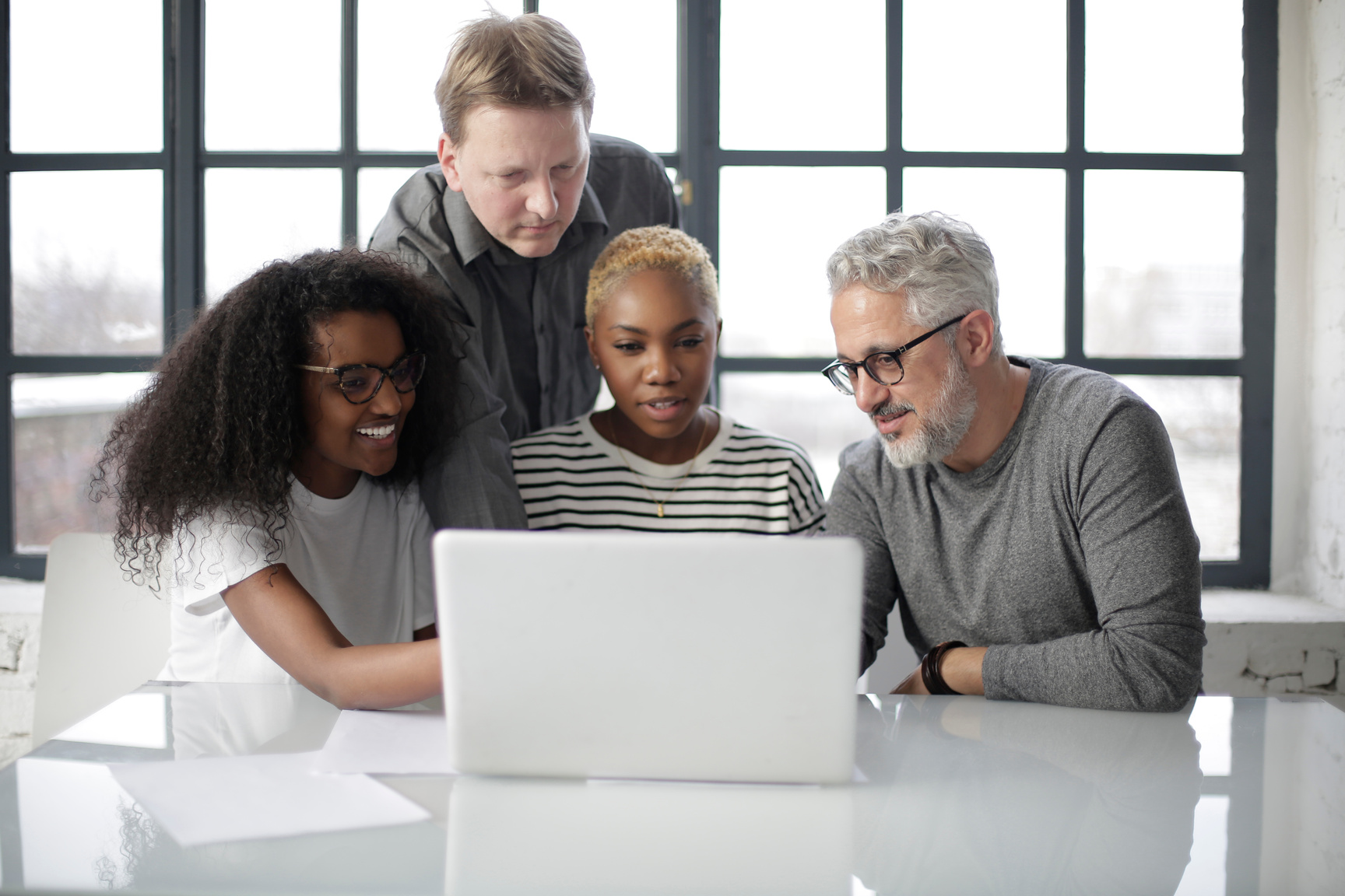 Positive diverse coworkers using laptop in office